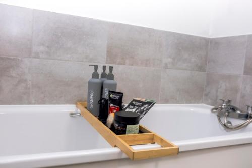 a bathroom with a bath tub with a shelf on the side of it at CENTRAL Luxury 2BR Apartment Manchester in Manchester