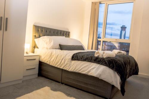 a bedroom with a large bed with a window at CENTRAL Luxury 2BR Apartment Manchester in Manchester
