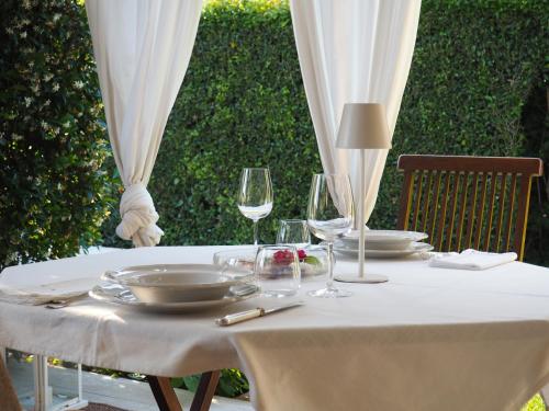 a table with a white table cloth and wine glasses at Aura Relais in Numana