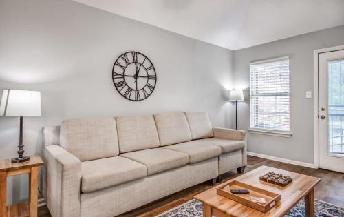 a living room with a couch and a clock on the wall at Dedo Days Retreat in Bartlett