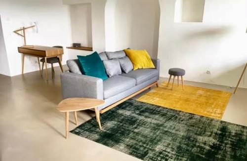 a living room with a couch and a table at 2 pièces vue Lac Lutry, Lausanne avec grande Terrasse in Lutry