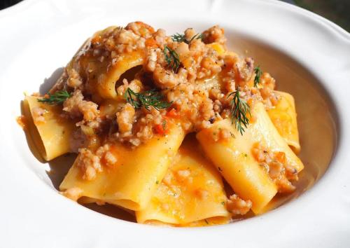 a white bowl of pasta with meat and sauce at Aura Relais in Numana