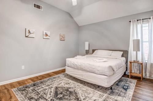 a white bedroom with a bed and a rug at Dedo Days Retreat in Bartlett