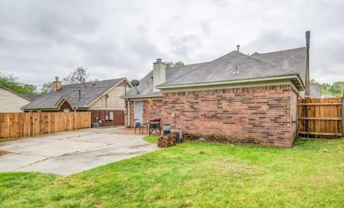 a brick house with a wooden fence in a yard at Dedo Days Retreat in Bartlett
