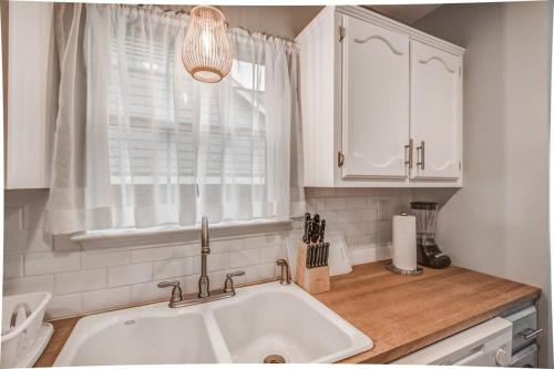 a white kitchen with a sink and a window at Dedo Days Retreat in Bartlett