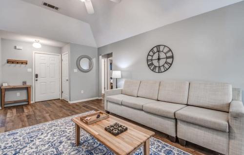 a living room with a couch and a clock on the wall at Dedo Days Retreat in Bartlett