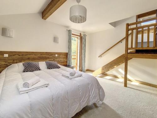 a bedroom with a white bed and a staircase at Chalet de standing spacieux avec terrasse et babyfoot - FR-1-344-1186 in Praranger