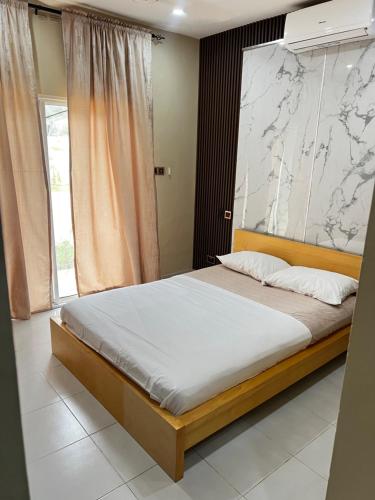 a bedroom with a large bed with a large painting on the wall at Cozy 2BR Bungalow Senegambia in Serekunda