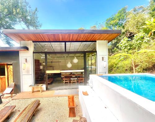 a house with a swimming pool next to a house at Ikiru House in Santa Teresa Beach