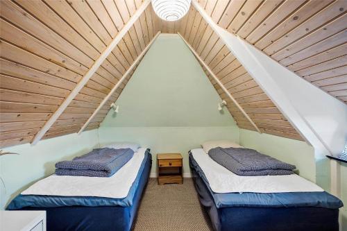 two beds in a room with a roof at 20398-Ulfborg-Hummelmosevej-7 in Sundhuse