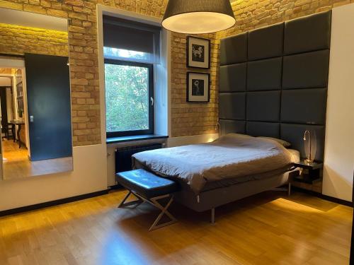 a bedroom with a bed and a large window at Downtown Retreat Loft-Industrial Studio in Rīga