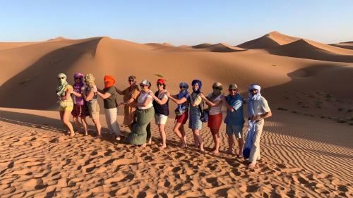 a group of people standing in the desert at Camp Desert Bivouac Chegaga in El Gouera