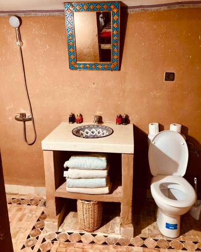 a bathroom with a sink and a toilet and a mirror at Camp Desert Bivouac Chegaga in El Gouera