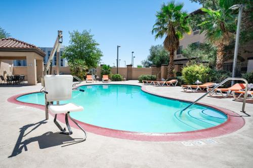 a swimming pool with a chair in the middle at Holiday Inn Express Hotel & Suites Barstow by IHG in Barstow