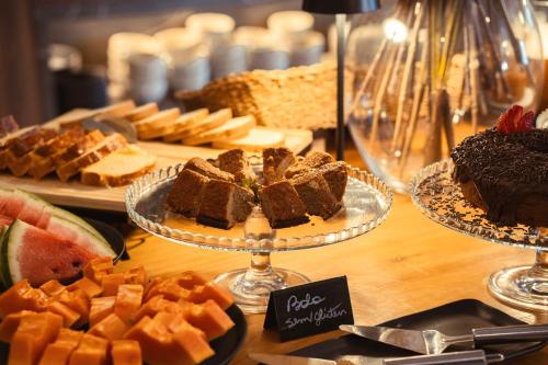 a table with different types of cakes and other desserts at Pousada Murano in Campos do Jordão