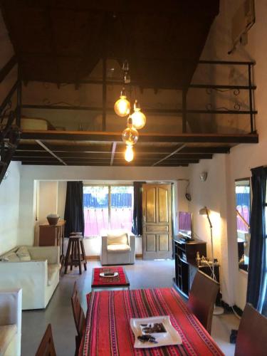 a living room with a couch and a table with a red rug at El milagro in La Reja