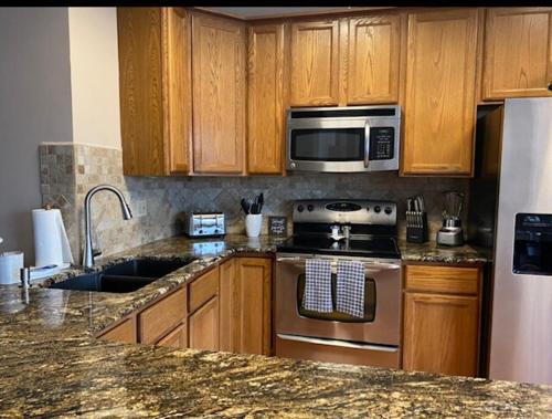 eine Küche mit Küchengeräten aus Edelstahl und Holzschränken in der Unterkunft The Loft at Bite Me BBQ in Wichita