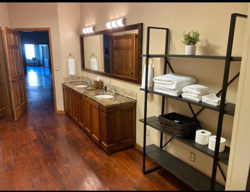 ein Badezimmer mit Waschbecken und Spiegel in der Unterkunft The Loft at Bite Me BBQ in Wichita