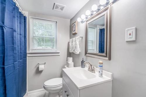Un baño con lavabo, inodoro y espejo. en Whitehaven Park Retreat, en Memphis
