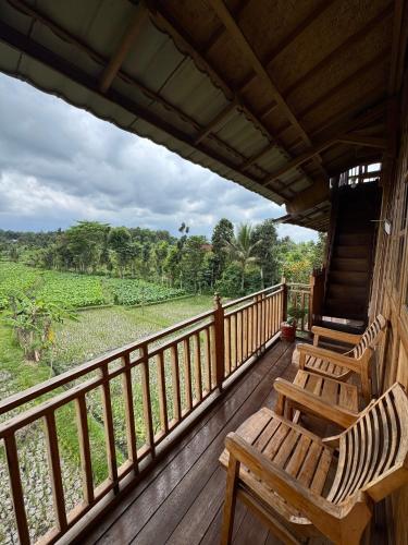 a porch with two chairs and a view of a field at Pesona 361 Alam Bungalows in Rarang
