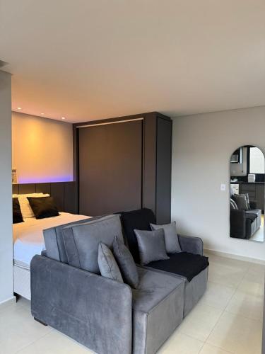a living room with a couch and a bed at Loft com ar-condicionado no Centro in Guarapuava