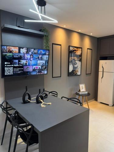 a room with a table with chairs and a flat screen tv at Loft com ar-condicionado no Centro in Guarapuava