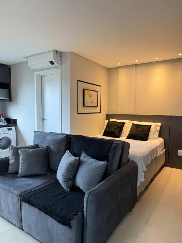 a living room with a couch and a bed at Loft com ar-condicionado no Centro in Guarapuava
