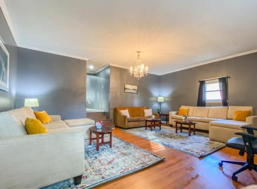 a living room with couches and a chandelier at Cardinal Aerie in Madison