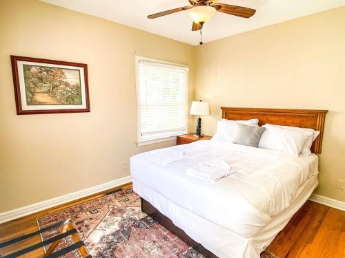 a bedroom with a large white bed with a ceiling fan at Bonita Bungalow in Huntsville