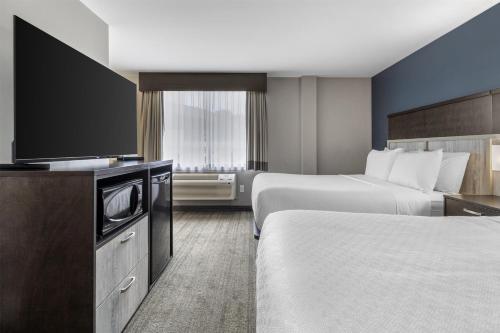 a hotel room with two beds and a flat screen tv at Best Western Plus Chocolate Lake Hotel - Halifax in Halifax