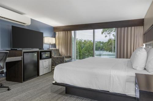 a hotel room with a bed and a desk and a tv at Best Western Plus Chocolate Lake Hotel - Halifax in Halifax