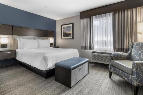 a hotel room with a bed and a chair at Best Western Plus Chocolate Lake Hotel - Halifax in Halifax