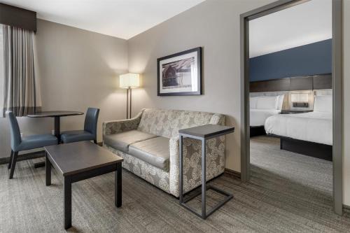 a hotel room with a couch and a bed at Best Western Plus Chocolate Lake Hotel - Halifax in Halifax