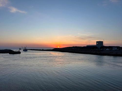 a sunset over a body of water with a boat at 70181-Ulfborg-Enghavevej-2 in Thorsminde