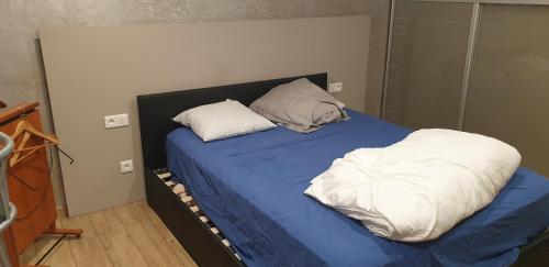 a bed with two pillows on it in a room at Séjour confortable sur péniche luxueuse in Brouckerque