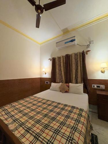 a bedroom with a bed and a ceiling fan at Kolkata Vintage Stay - 2BHK with Bengali Home Vibe in Kolkata