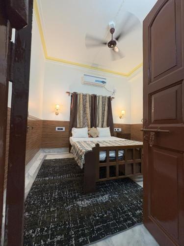 a bedroom with a bed and a ceiling fan at Kolkata Vintage Stay - 2BHK with Bengali Home Vibe in Kolkata