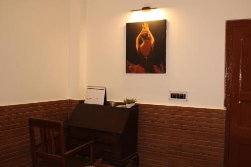 a room with a piano and a picture on the wall at Kolkata Vintage Stay - 2BHK with Bengali Home Vibe in Kolkata