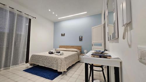 a bedroom with a bed and a desk in it at "Il Faro" con terrazza attrezzata all'aperto in Santa Flavia