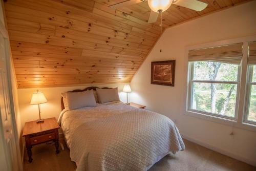 a bedroom with a bed and a window at Retriever Beach - New River-frontage with Your Own Private Beach! Fire Pits - Games and More! in Glendale Springs