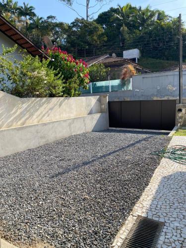 a driveway with a retaining wall and a garage at Casa ampla com área externa e estacionamento in Brusque