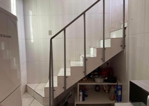 a staircase with glass railing in a room at Duplex familiar in Contagem