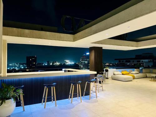 a bar on the roof of a building with a view at A Tranquil Studio in Airport Residential with Pool - The Essence in Accra