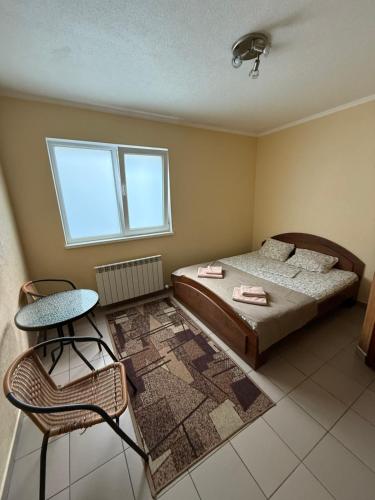 a bedroom with a bed and a chair and a window at Sava Dream in Zhytomyr