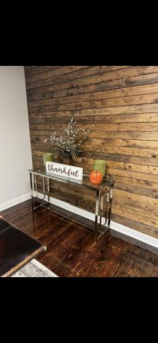 a wooden wall with a table with a pumpkin on it at Boone Trace Inn Room 5 in Pineville