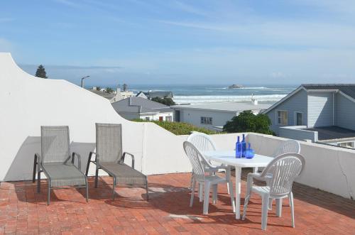 a patio with a table and chairs and the ocean at 13 on Main in Yzerfontein