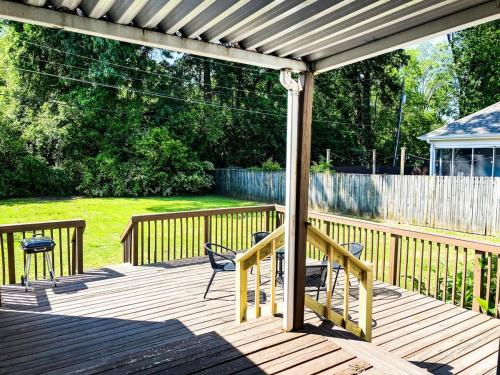 a wooden deck with chairs and a pergola at Bonita Bungalow in Huntsville