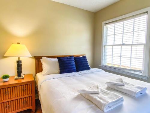 a bedroom with a bed with blue pillows and a window at Bonita Bungalow in Huntsville