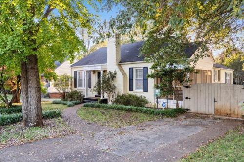 a white house with a tree and a fence at Cali St Rocket City Residence in Huntsville