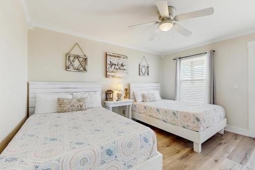 a bedroom with two beds and a ceiling fan at Malibu Beach House in Dauphin Island